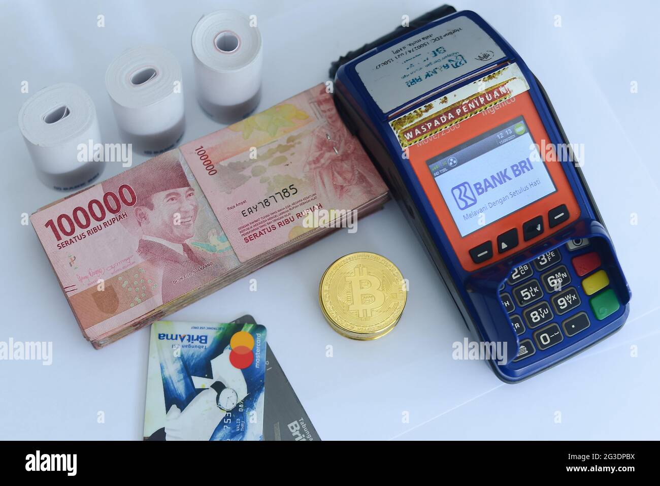 pile of hundred thousand rupiah banknotes along with BANK BRI credit cards  and bitcoins and also an EDC (ELECTRONIC DATA CAPTURE BANK BRI) machine, th  Stock Photo - Alamy