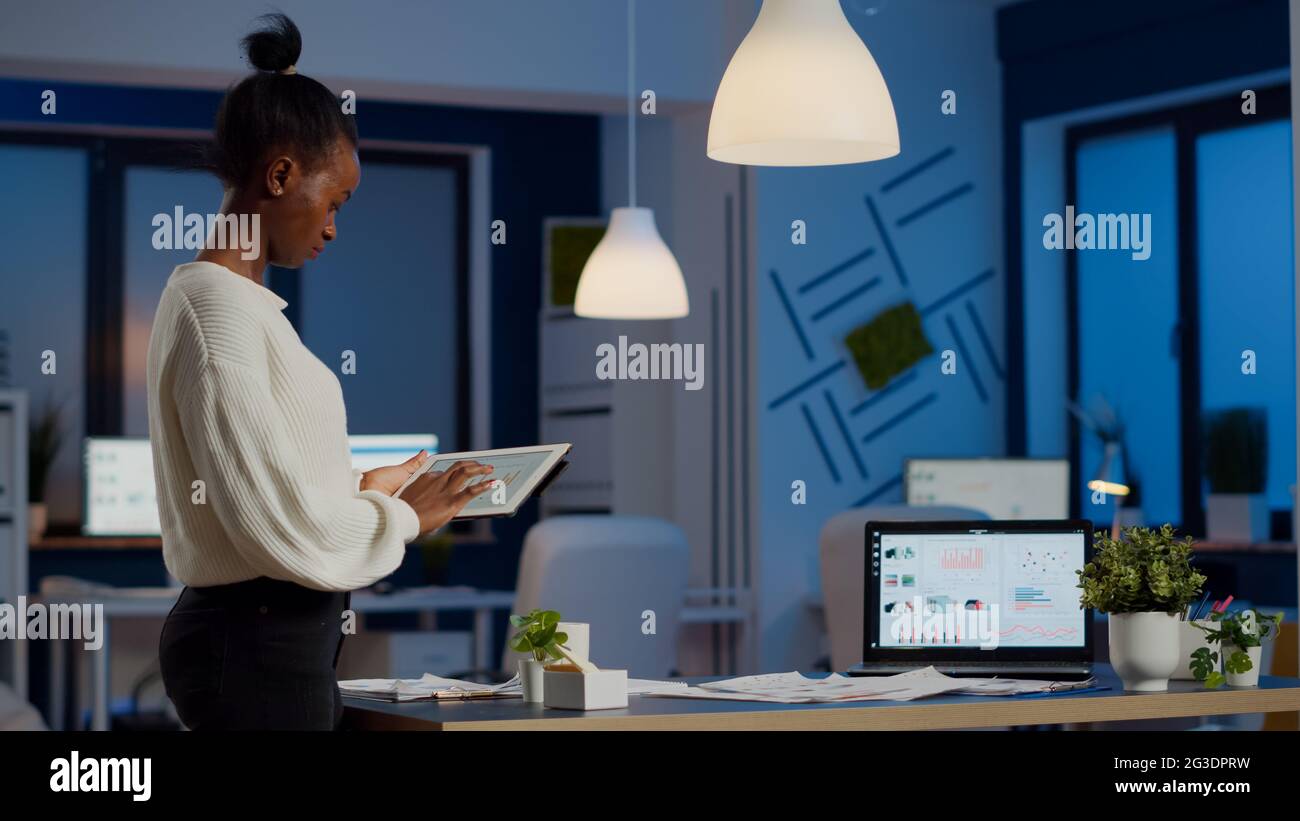 Curated visual reference: Picture Idea: Black Woman Employee Stanging In Office And Analysing Charts During