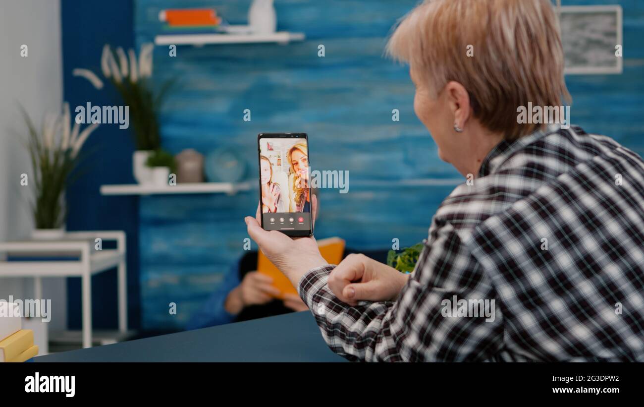 Senior woman having video call online talk with nephew using smartphone ...