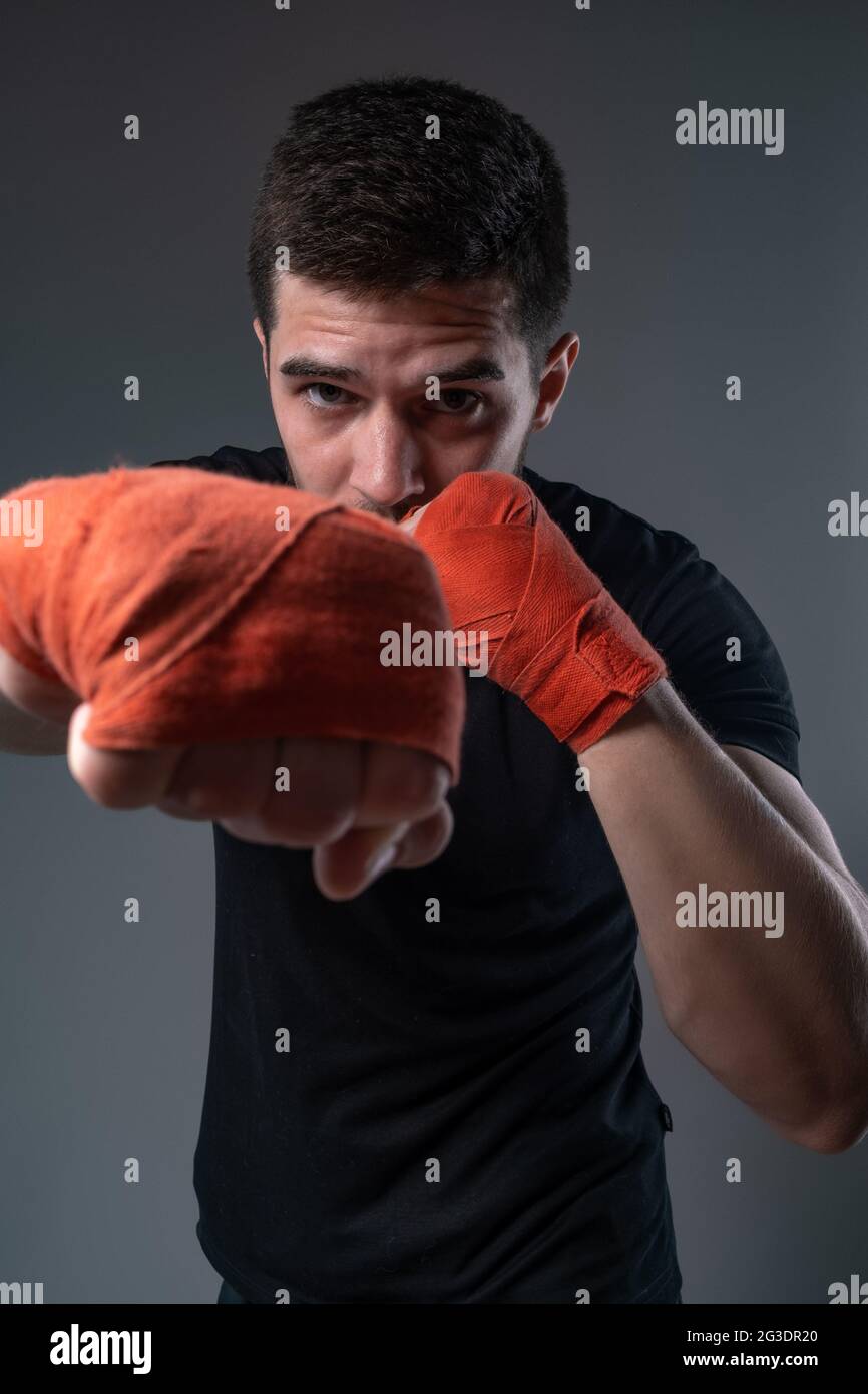 Sportsman throwing right straight punch with hand in wrist wraps Stock Photo Alamy