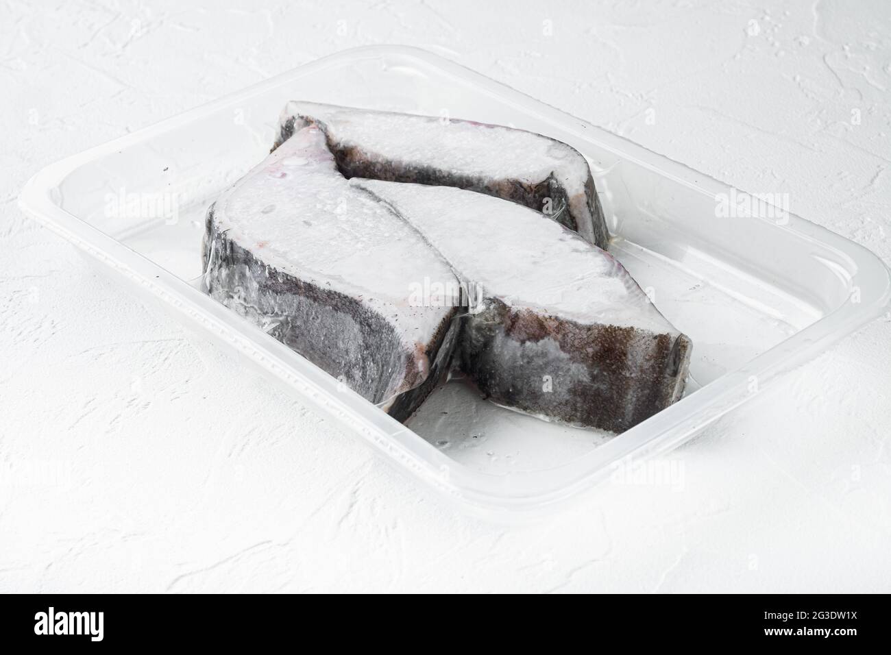 Raw fillets frozen halibut airtight vacuum pack set, on white stone