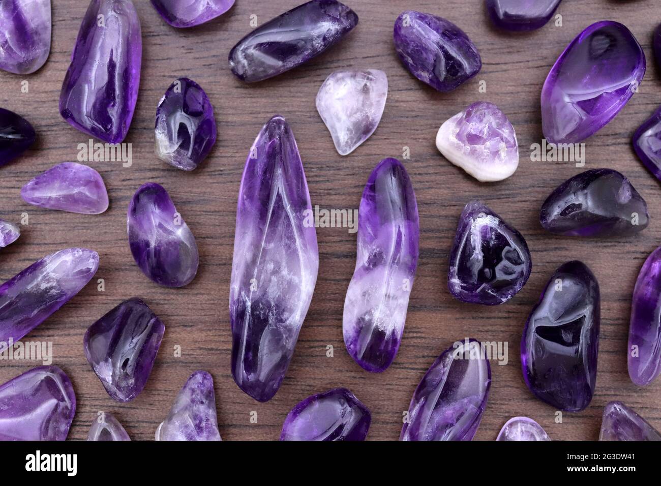 Amethyst rare jewel stones texture on brown varnished wood background Stock Photo