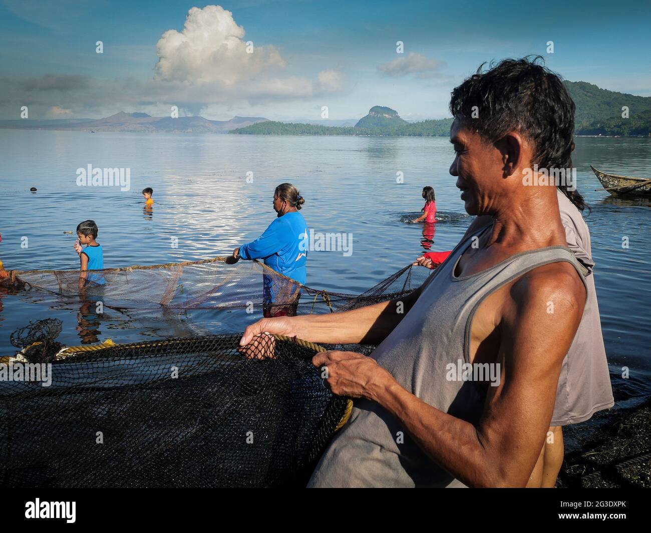 Community Volunteer pulls mightily the rope as they trawl the net back to  the shore in Taal Lake, Balete, Batangas, Philippines. 15th June, 2021.  First time for this fishing village to catch