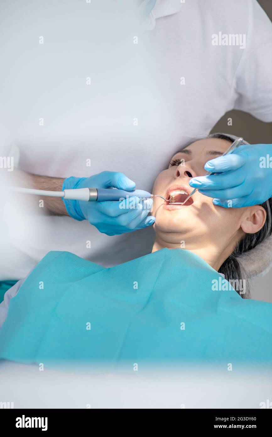 Dentist working on patients teeth restoration and making dental filling