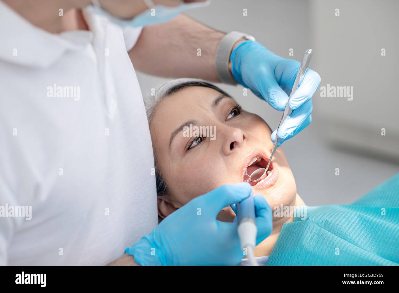 Dentist working on patients teeth restoration and making dental filling
