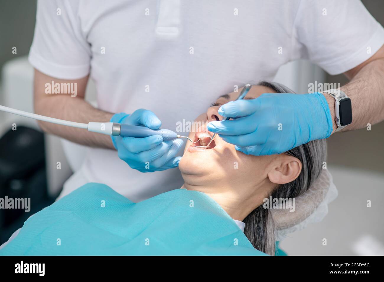 Dentist working on patients teeth restoration and making dental filling