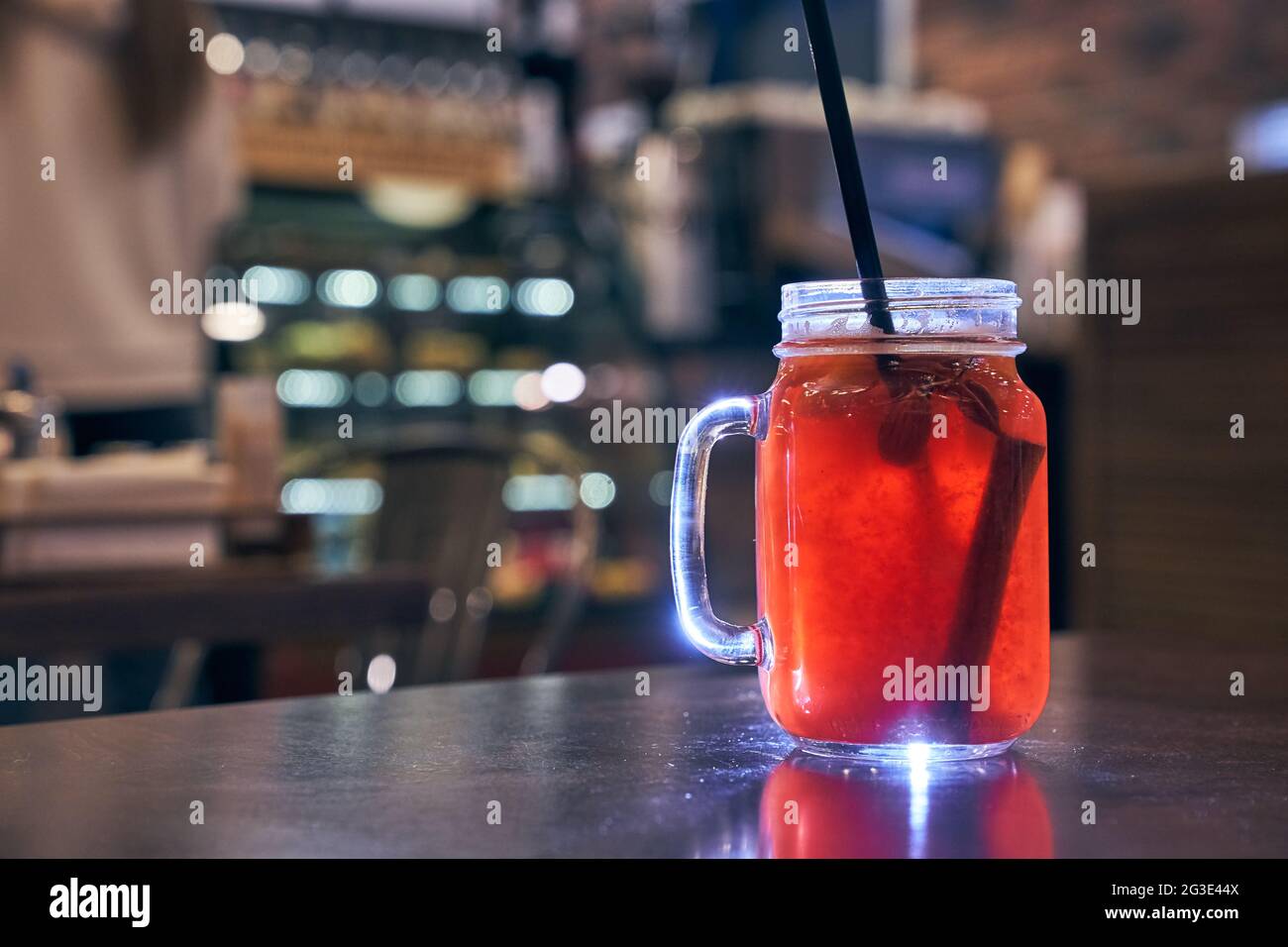 Christmas drink red non-alcoholic mulled wine with a straw on the background of the cafe interior, order for one Stock Photo