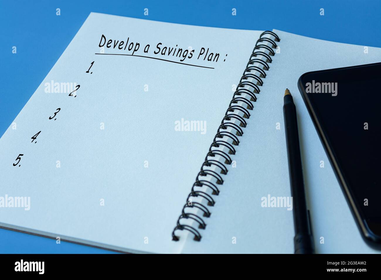 Text on notepad with pen and smartphone on blue background Stock Photo