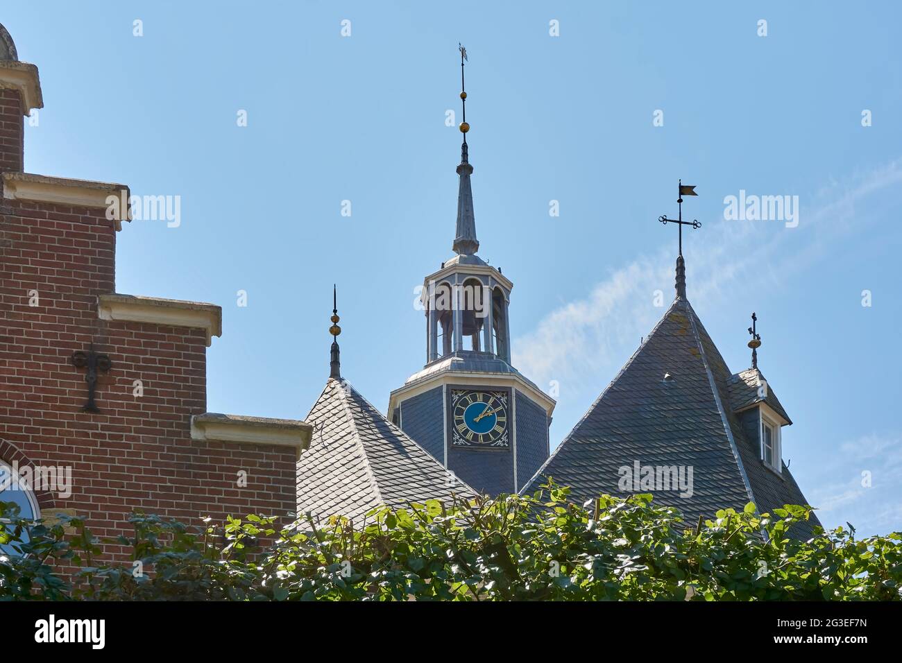 View on the Jouster Toren or Jouster Toer in Joure against a blue sky. In the front a house with a stepped gable. Stock Photo