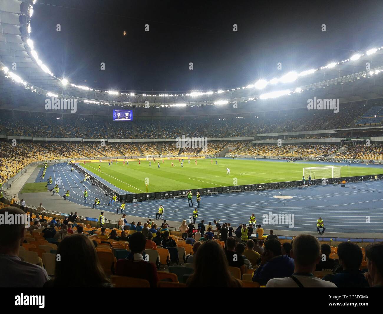 Football competition in a large stadium in the evening with a bright highlight removed from the stands Stock Photo