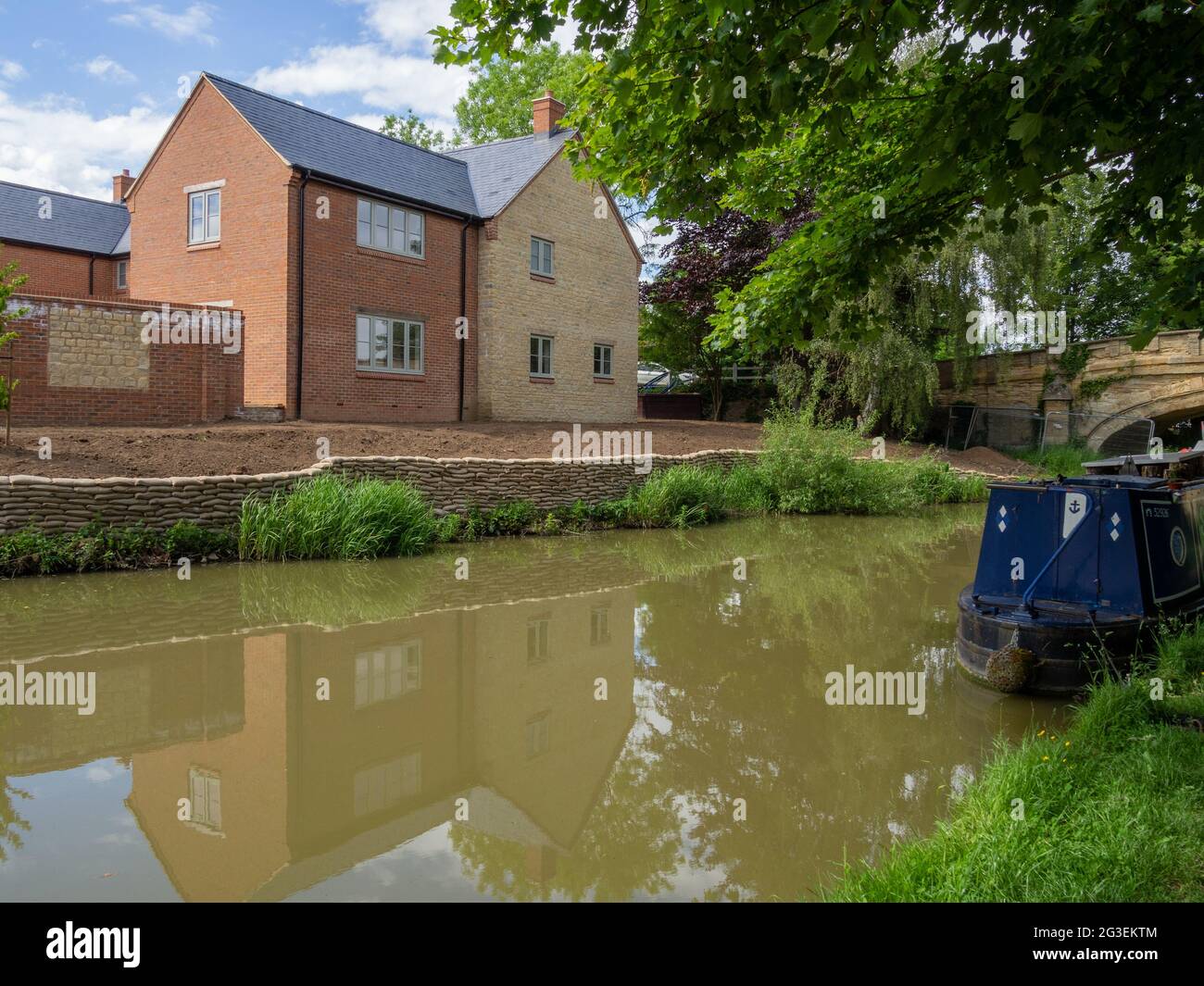 New houses being built on the side of the Grand Union canal, Cosgrove, Northamptonshire, UK Stock Photo