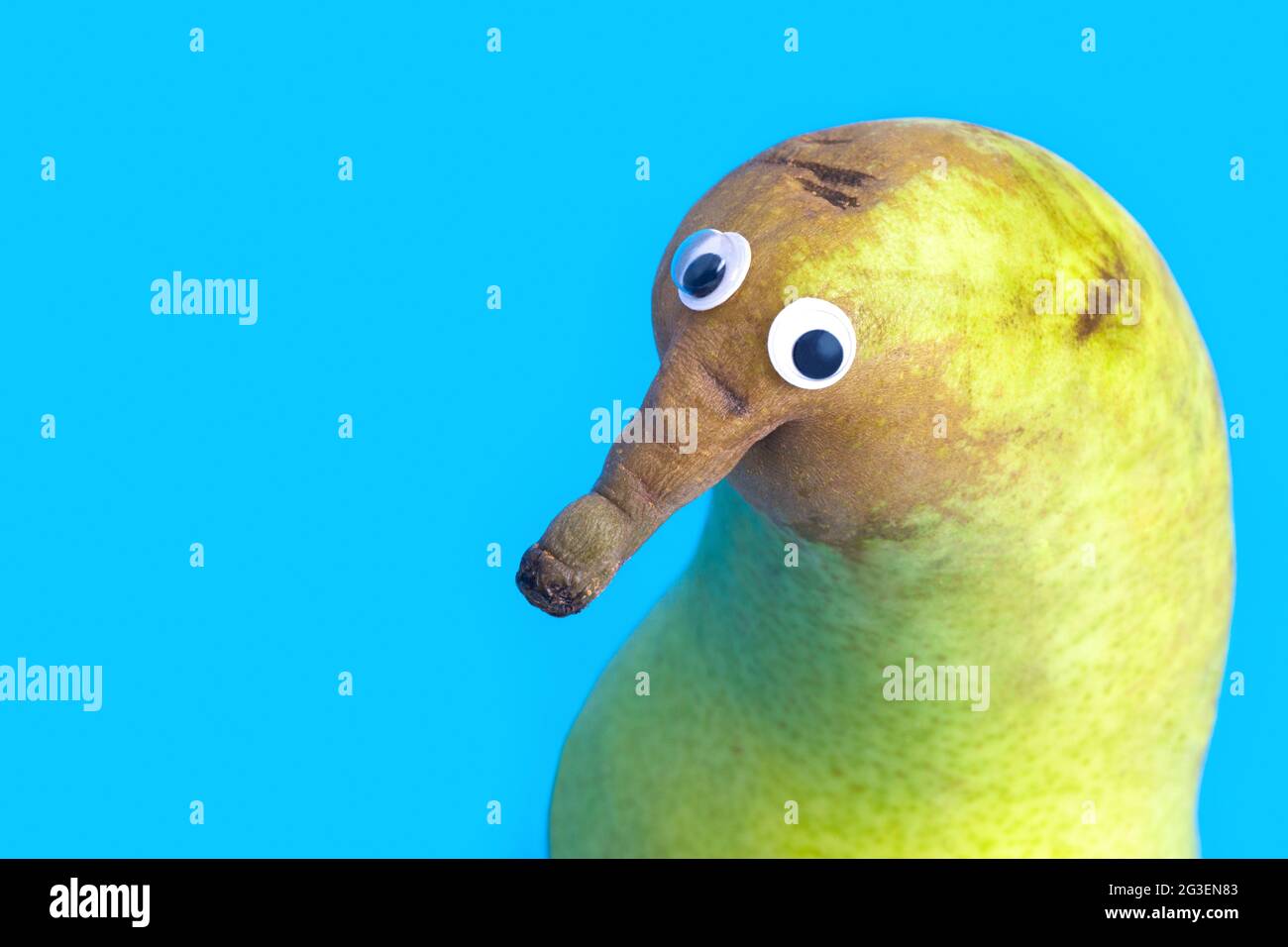 Funny pear character making puppy eyes isolated on blue Stock Photo