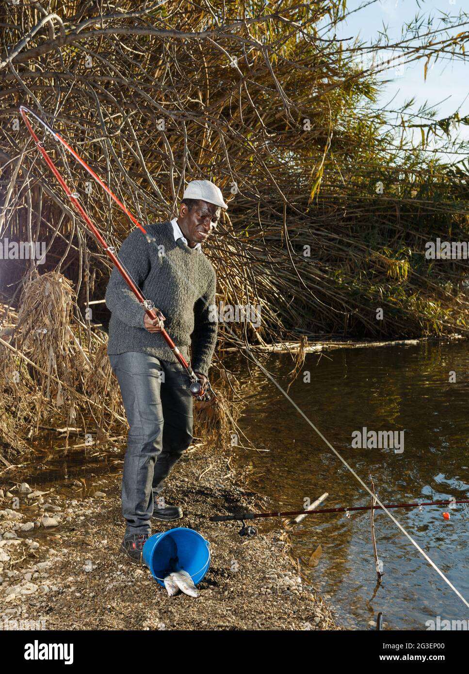Afro fisherman pulling fish Stock Photo