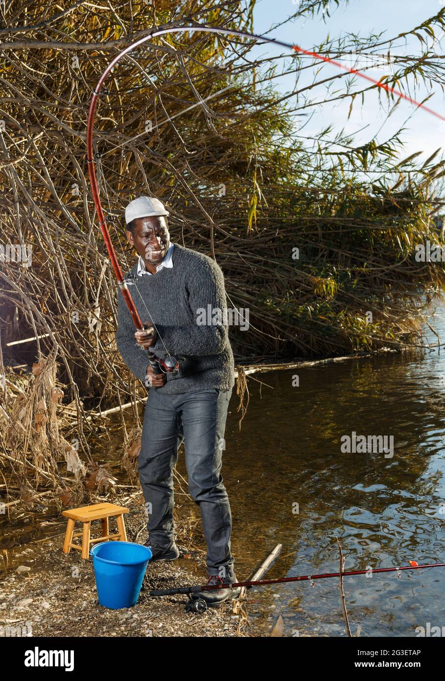 Man and pulling fish near river Stock Photo