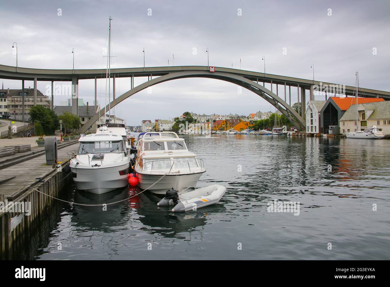Risoy bridge over the river in the center of the town. Surrounded by traditional buildings and boats in the water, Haugesund, Norway. Stock Photo