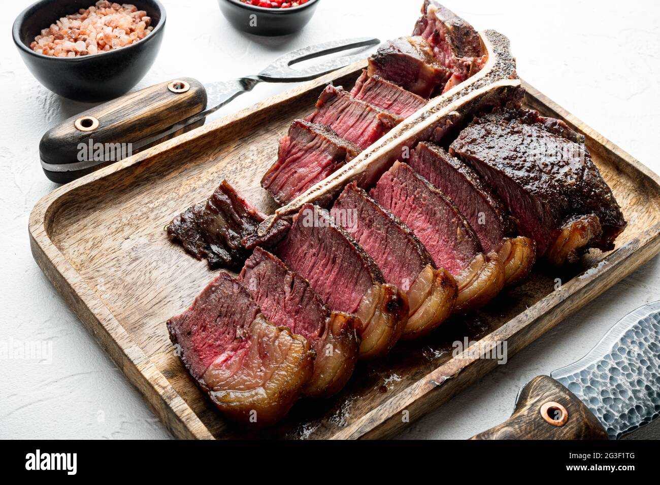 Grilled medium rare t bone or Porterhouse steak set, on white stone