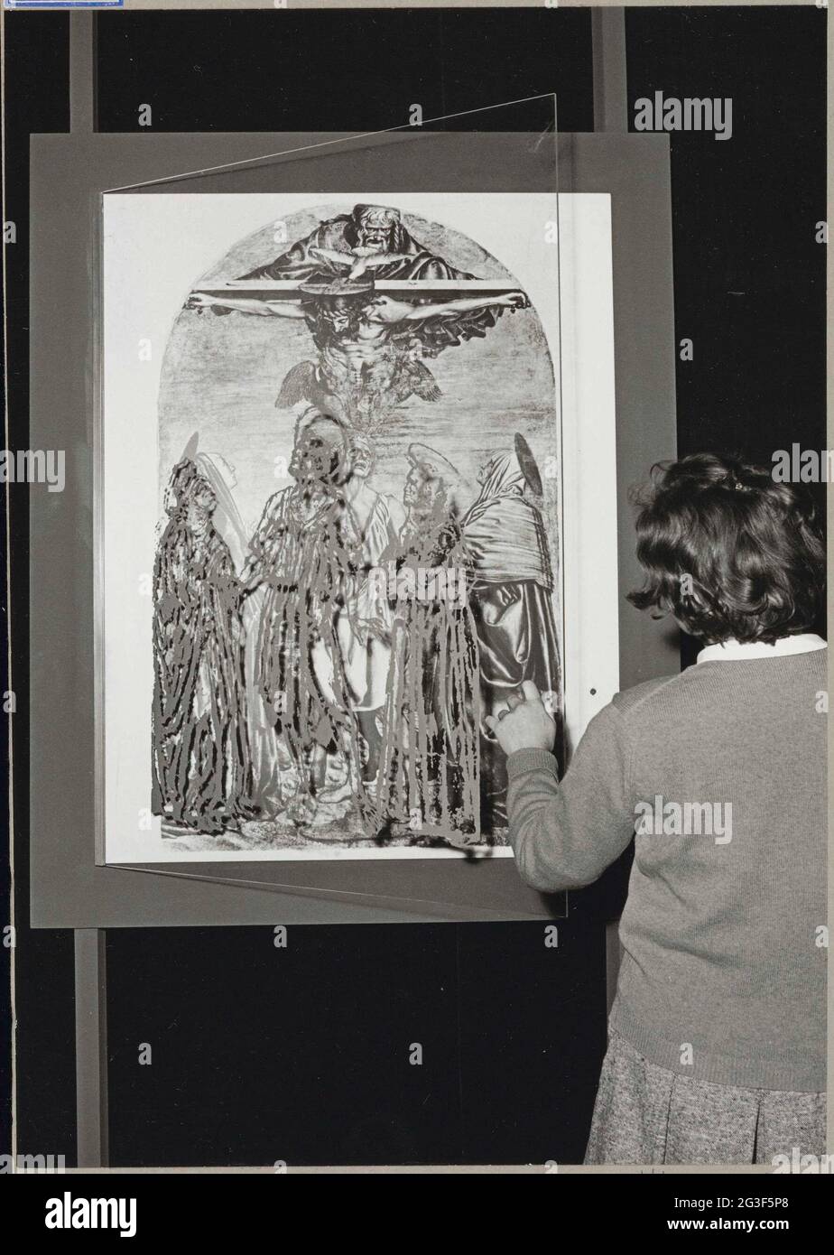 Visitor looks at a part of the exhibition; Exhibition Frescoes from Florence. Behind the glass door that the visitor holds a picture of the trinity and the holy hieronymus with the Holy Paula and Eustochium of Andrea del Castagno. Negative strip contains two comparable photos. Stock Photo