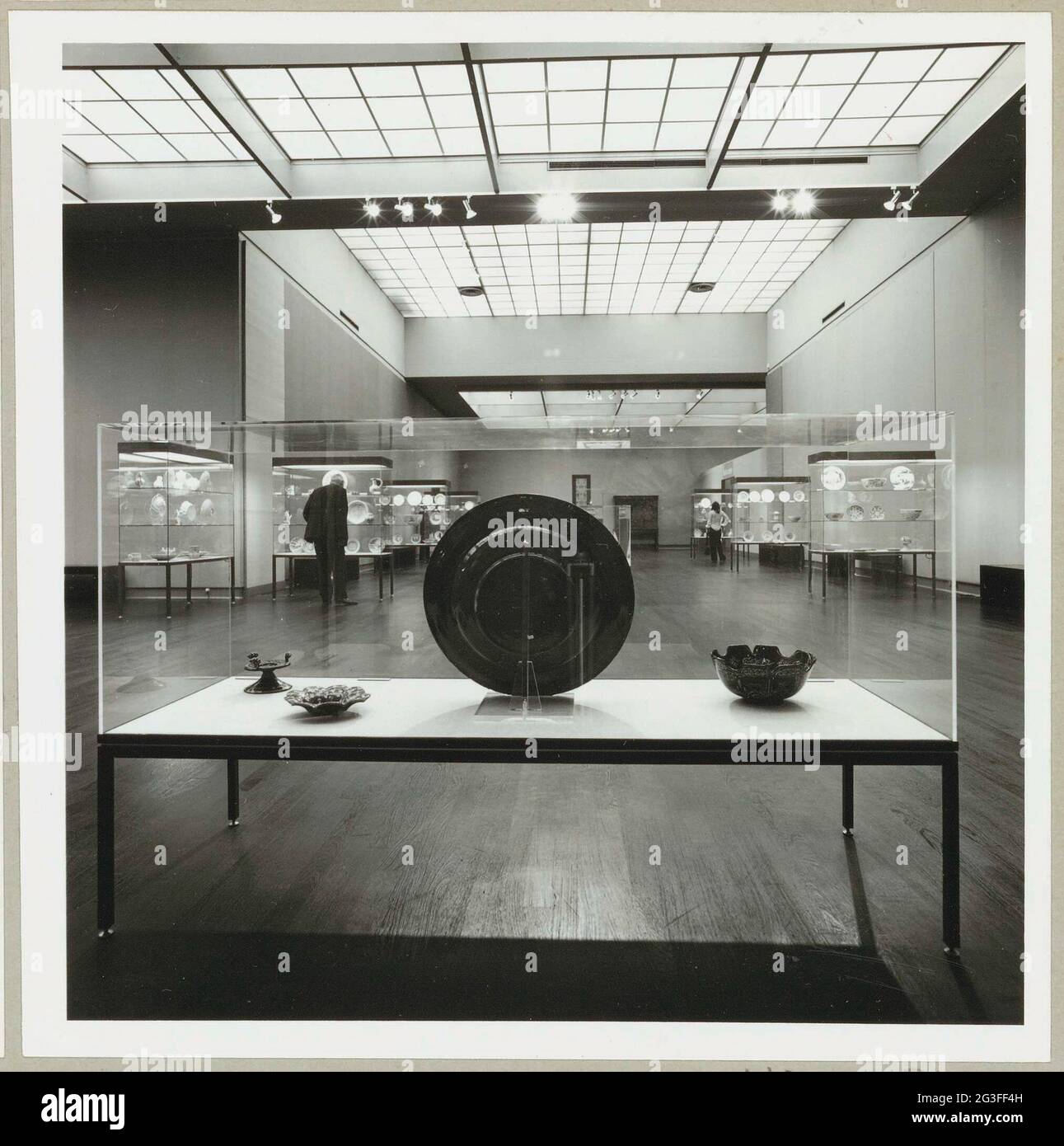 Room with various objects in showcases and two visitors; Exhibition ...