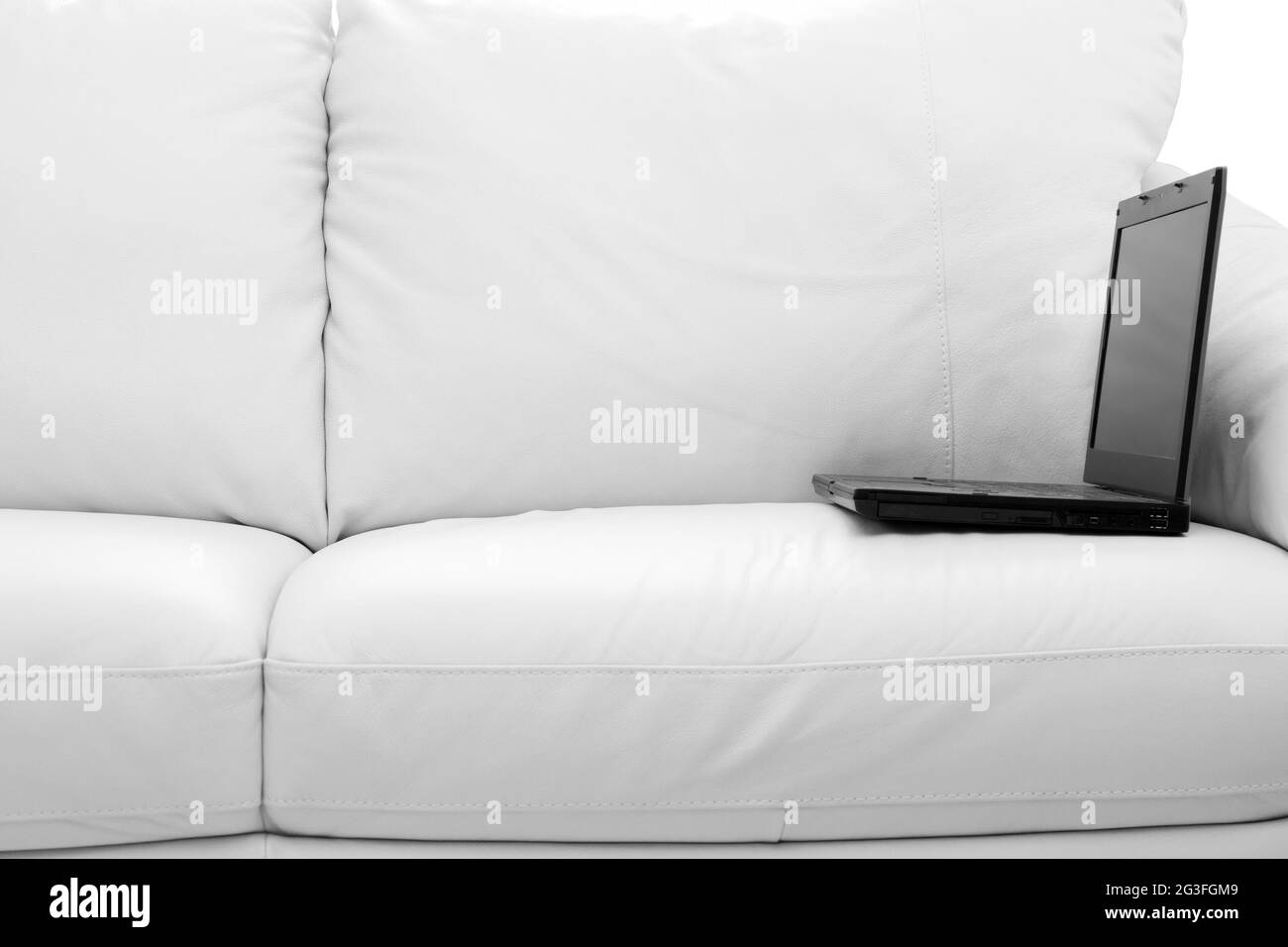 Black laptop computer on white sofa Stock Photo