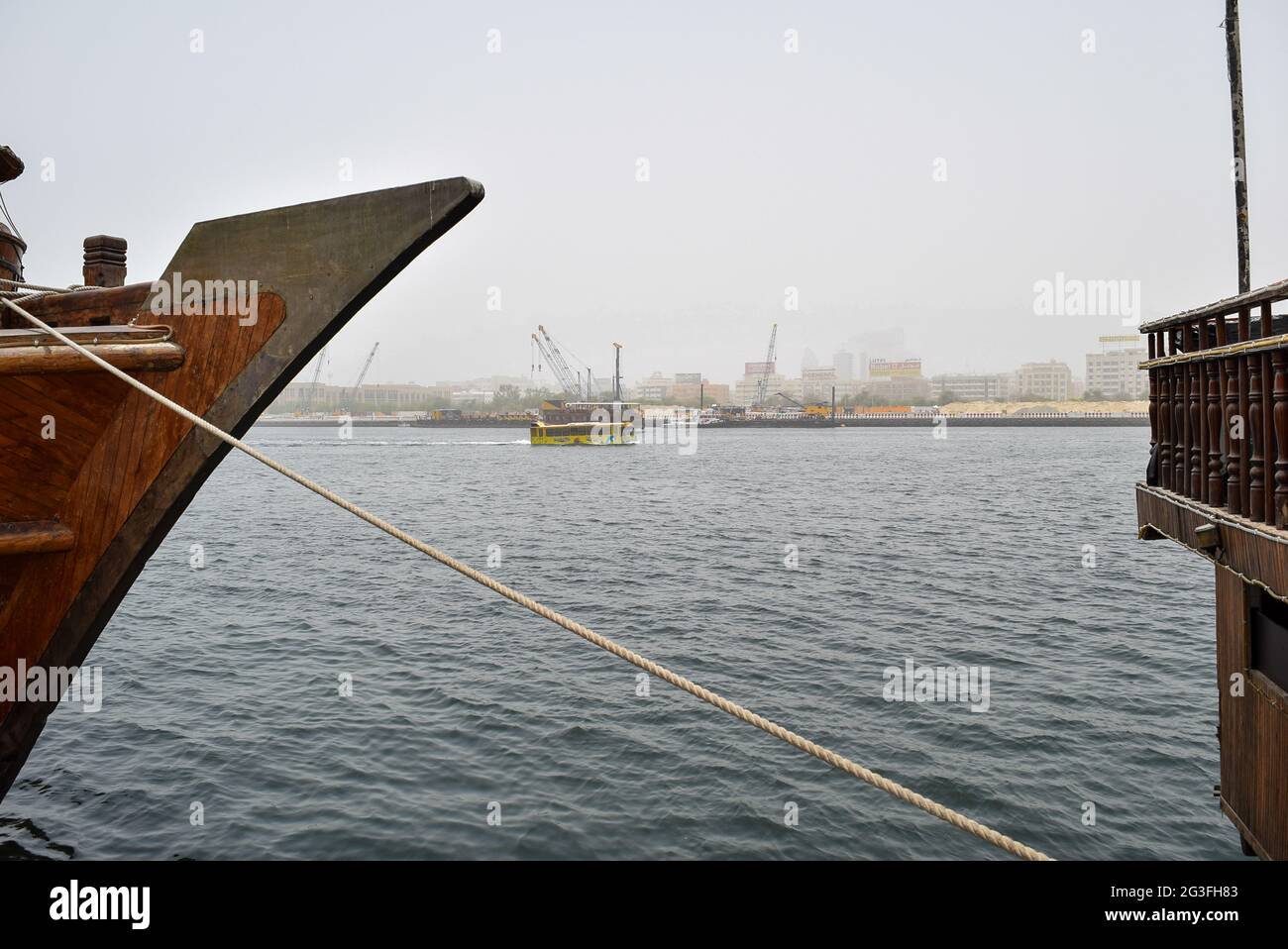 Edge of traditional wooden boat with restaurant in Dubai creek Area, UAE. Stock Photo
