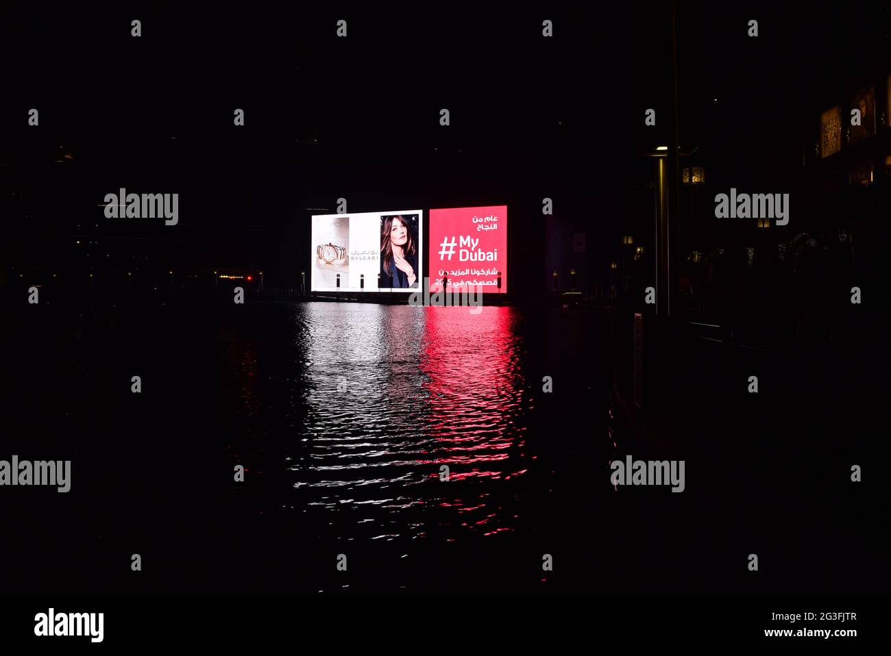 Reflection of billboard on Dubai mall fountain water in the nigh time, UAE. Stock Photo