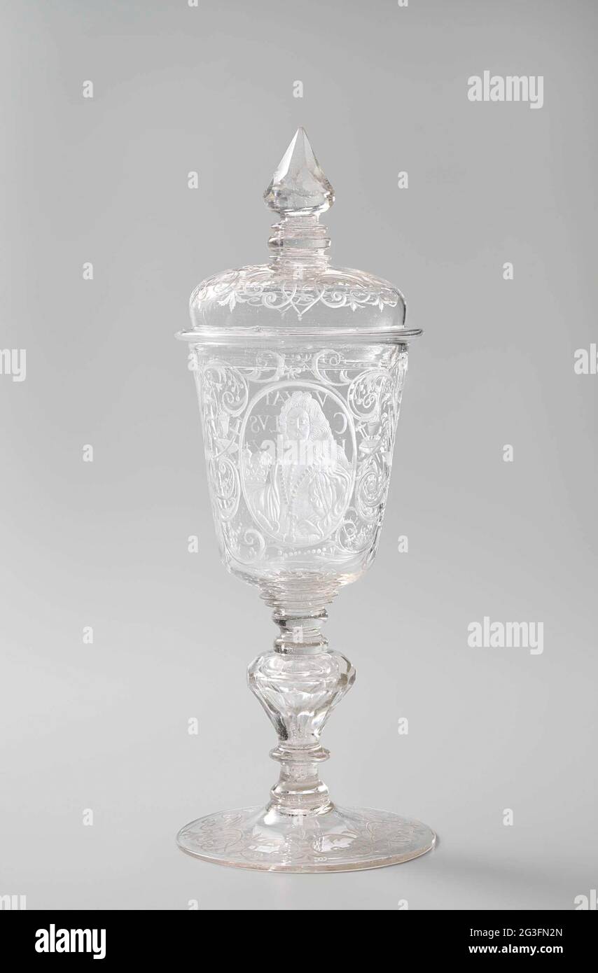Cup with lid, with the portrait of Charles VI. Vaulted foot. Hollow, facet cut, baluster-shaped strain with three buttons and three writing. The conical chalice has a rounded bottom. The vaulted lid has a pointed crown on a button and two writing. On the chalice The portrait of Emperor Charles VI from Habsburg (1685-1740) in an oval medallion. He is wearing the Insignia of the Golden Fleece. Left of him a crown. On the other side, in an oval medallion the text: VIVAT / CAROLUS / III / REX / HISPA / NIAE. To the left of the portrait Two drums with drumsticks, right a crowned helmet with closed Stock Photo