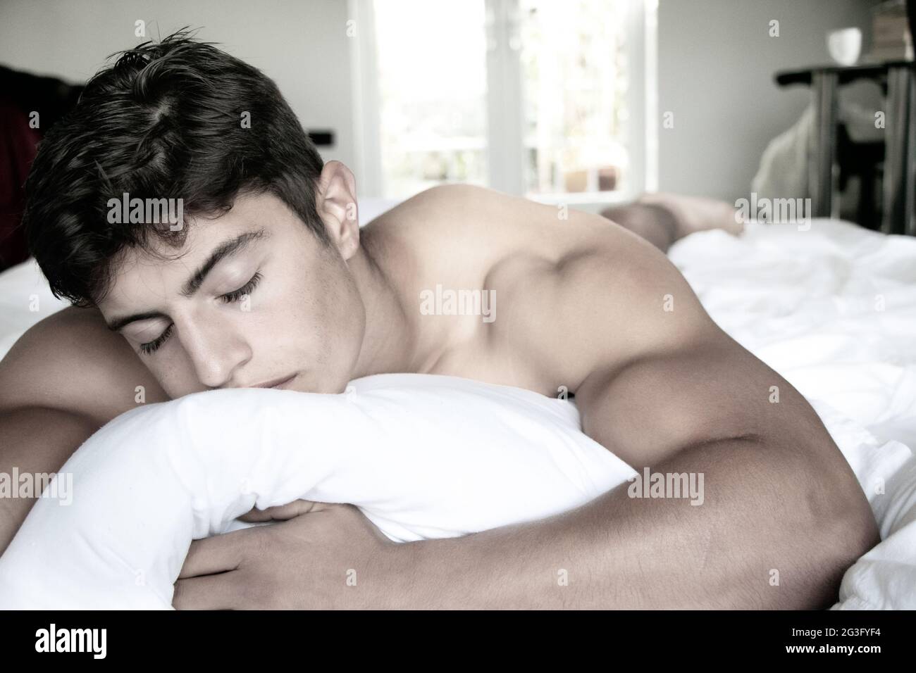Sexy, naked muscular man sleeping on bed Stock Photo