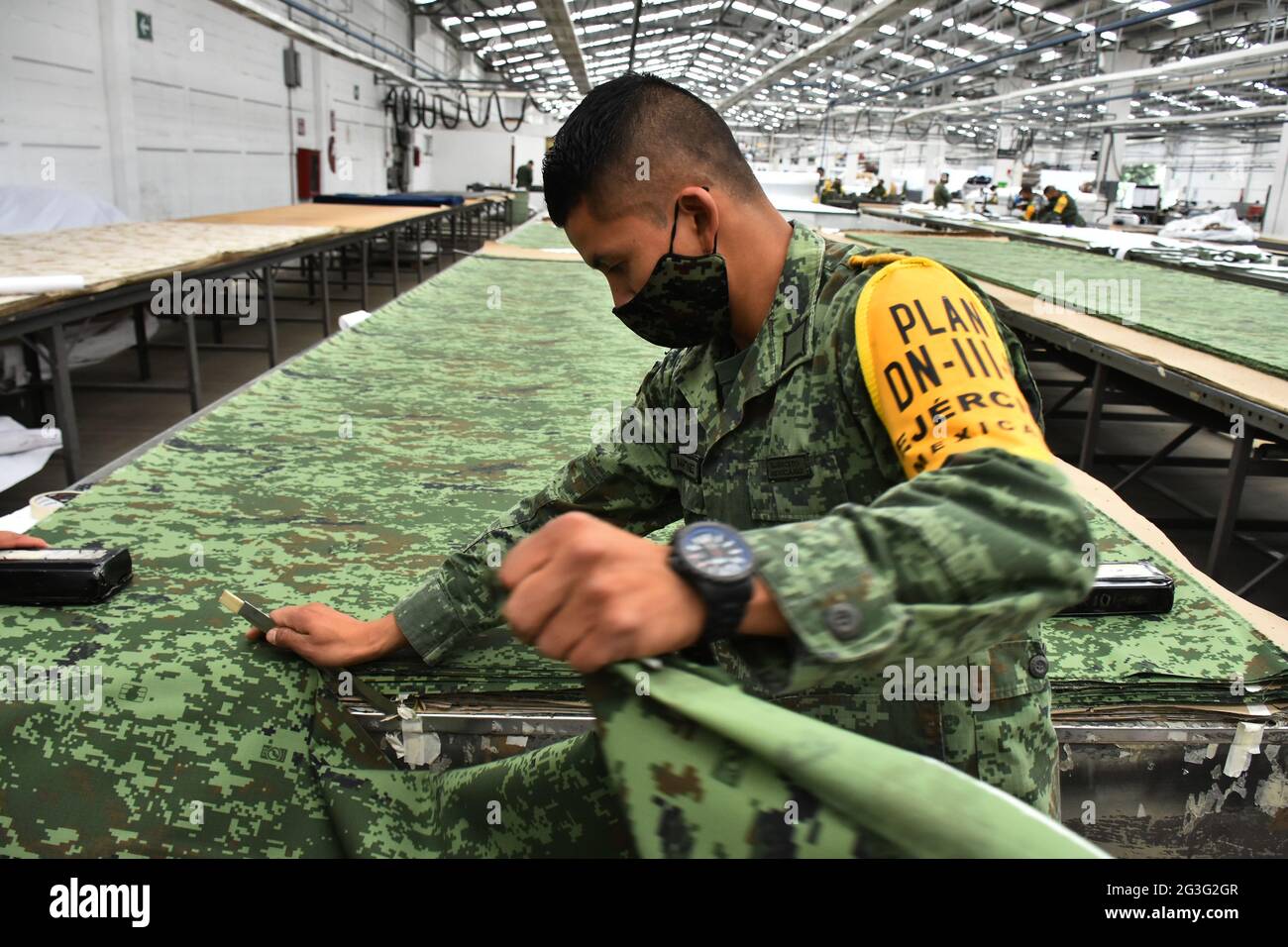 A military worker manufactures uniforms for members of Mexican Army at