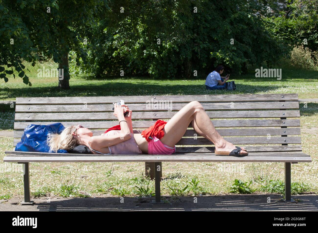 UK Weather, London: on the hottest day of the year so far, with temperatures expected to reach 29 centigrade, Londoners use Regent's Park to cool off or enjoy the sun. Some go on the pedallos, others hire a deckchair or grab a bench. Some are in bikinis, others fully clothed and even with face masks on outdoors. A cooling breeze makes the sun bearable but many stay in the shade. Anna Watson/Alamy Live News Stock Photo