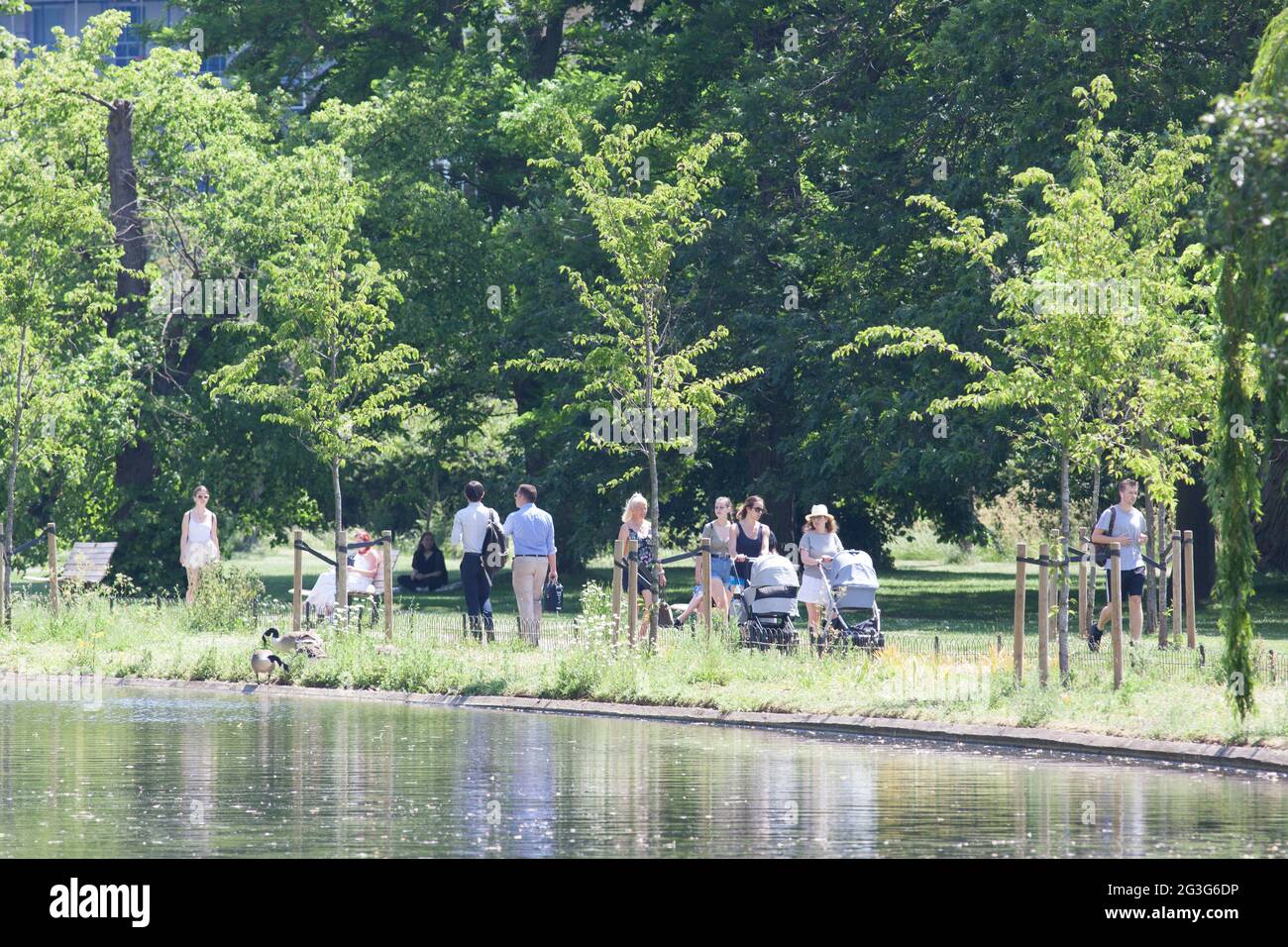 UK Weather, London: on the hottest day of the year so far, with temperatures expected to reach 29 centigrade, Londoners use Regent's Park to cool off or enjoy the sun. Some go on the pedallos, others hire a deckchair or grab a bench. Some are in bikinis, others fully clothed and even with face masks on outdoors. A cooling breeze makes the sun bearable but many stay in the shade. Anna Watson/Alamy Live News Stock Photo