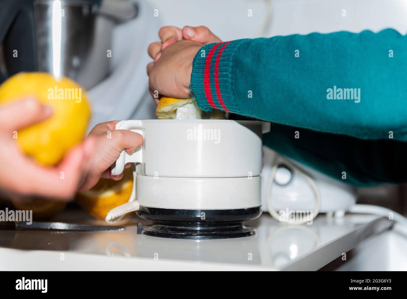 kids working together indoor kitchen enjoy juice whith machine squeezed Stock Photo