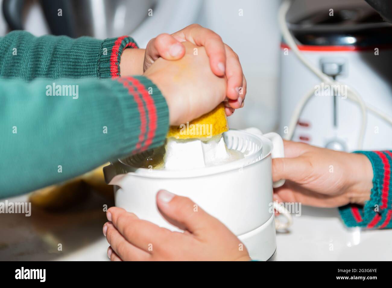 kid working together indoor kitchen enjoy juice whith machine squeezed Stock Photo