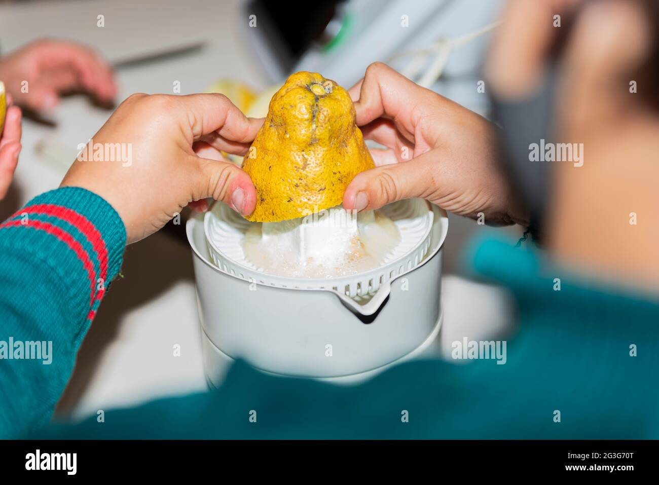kid enjoy together make juice with machine squeezed in kitchen indoor Stock Photo