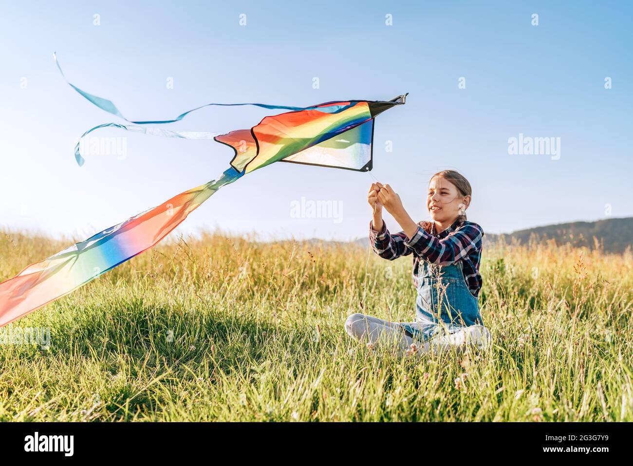 #5 Result of 9yo girl 9YO smiling girl sitting on the grass and preparing colorful rainbow kite toy for flying. Happy childhood moments or outdoor time spending concept ima Stock Photo - Alamy (NONE of the images is related to this website.) 9yo girl 9YO smiling girl sitting on the grass and preparing colorful rainbow kite toy for flying. Happy childhood moments or outdoor time spending concept ima Stock Photo - Alamy