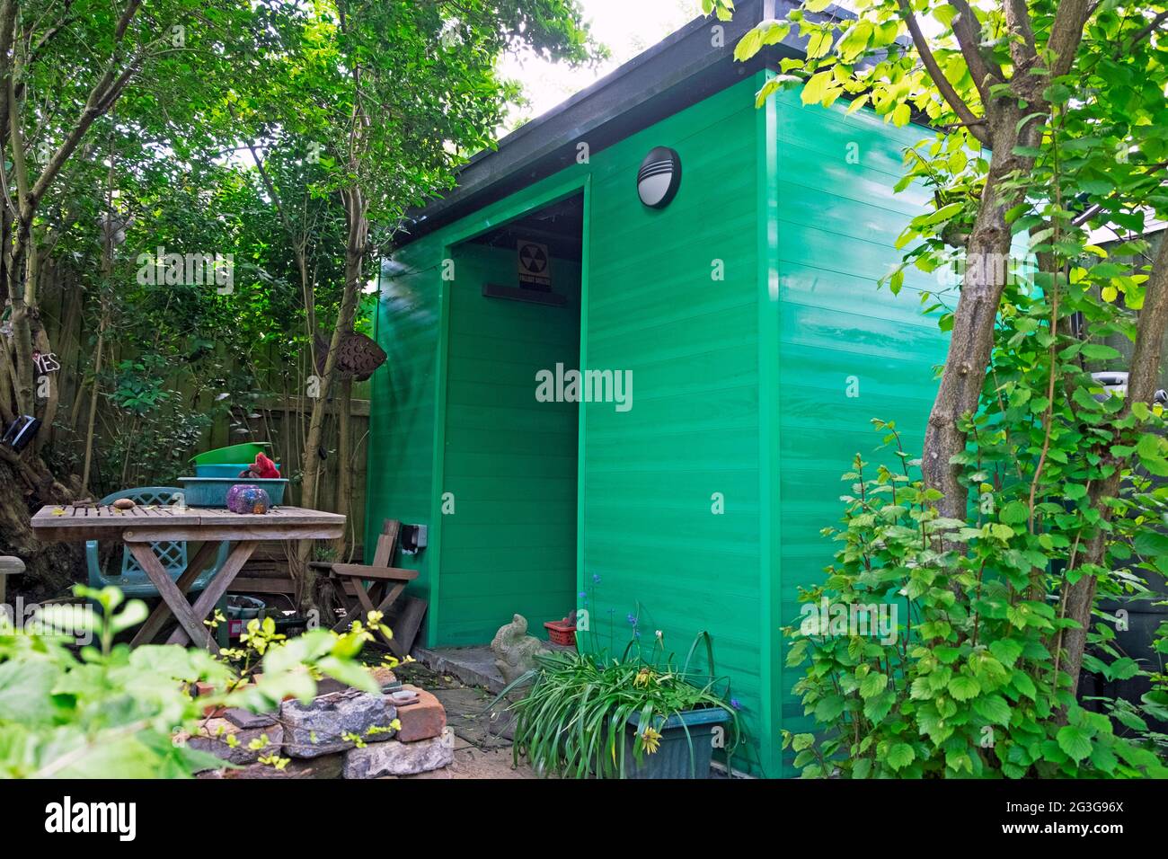 Green garden shed made with recycled materials in a London backyard back garden England UK  KATHY DEWITT Stock Photo