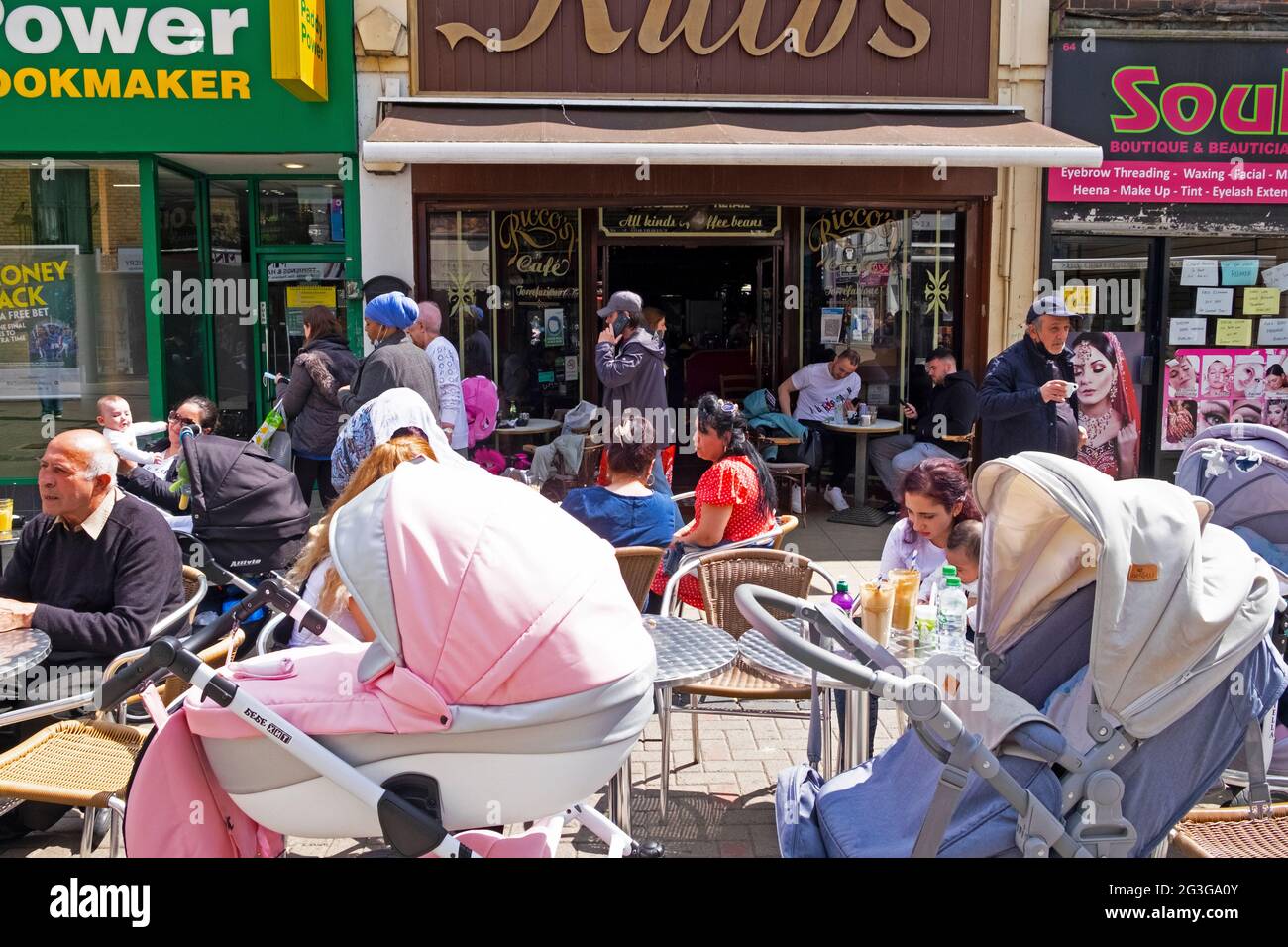Customers people mothers & prams sitting eating and drinking at tables  outside Ricco's restaurant Walthamstow High Street London E17 UK KATHY DEWITT Stock Photo