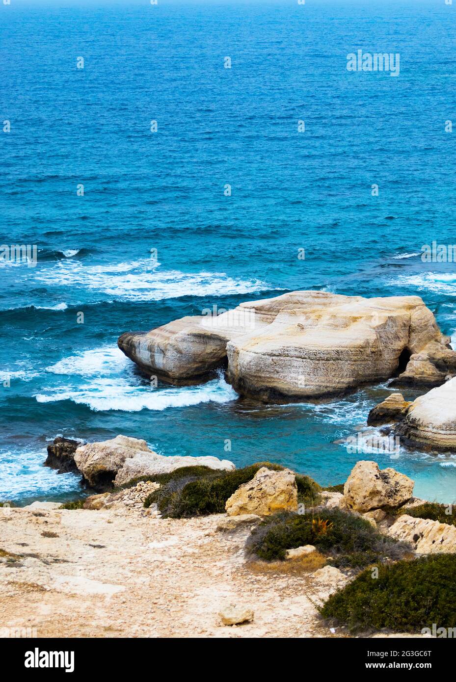 Ocean waves splash against beach with rocks background, Cliffs in the sea, Top aerial view of
