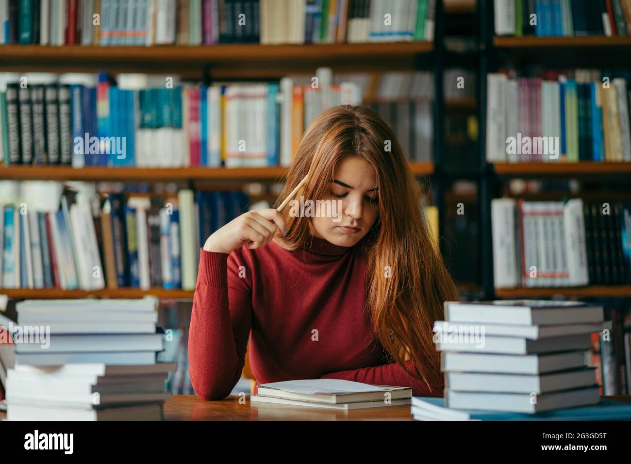 A girl holding a book shelf, student in the library Stock Photo - Alamy