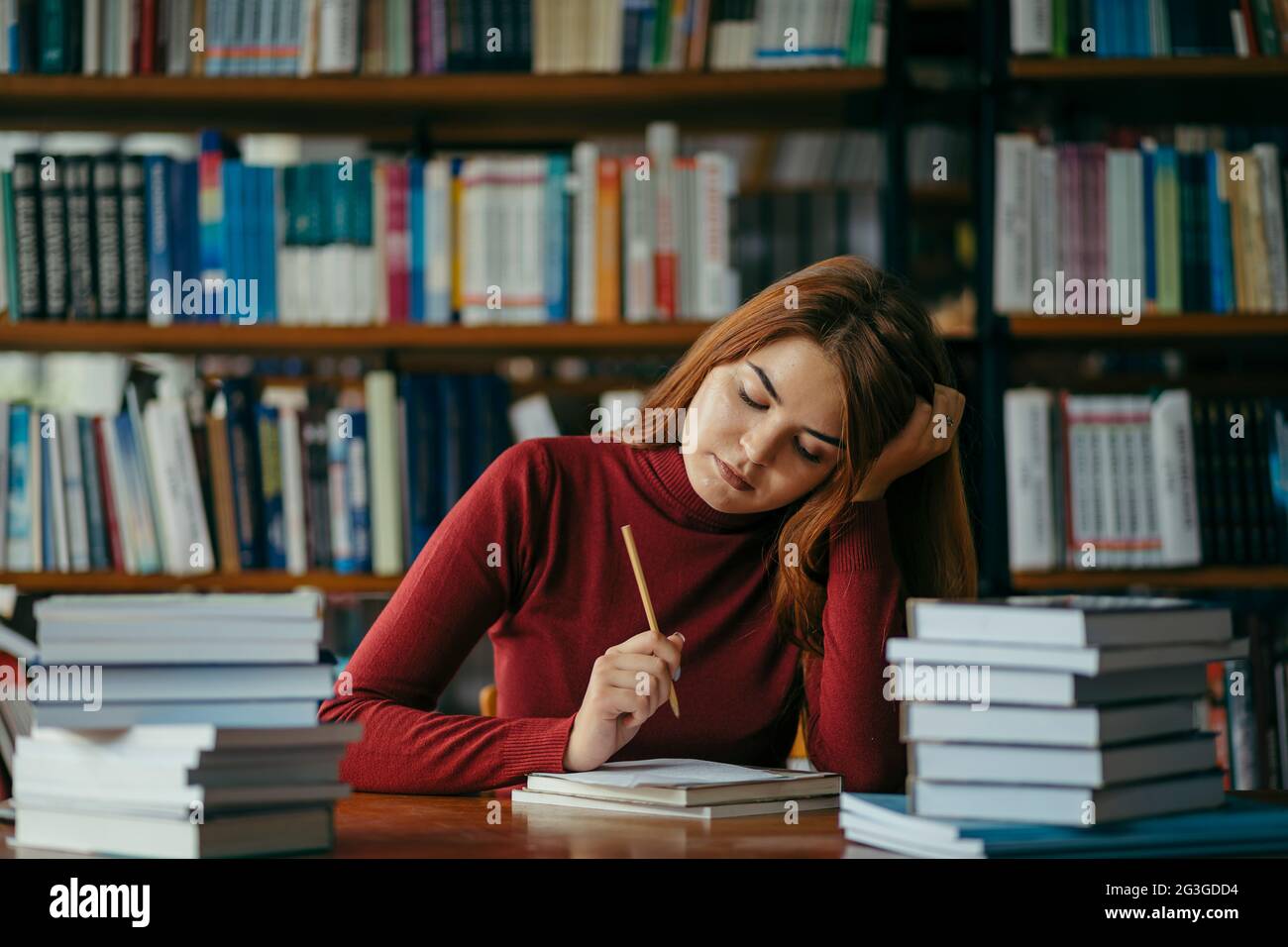 A girl holding a book shelf, student in the library Stock Photo - Alamy
