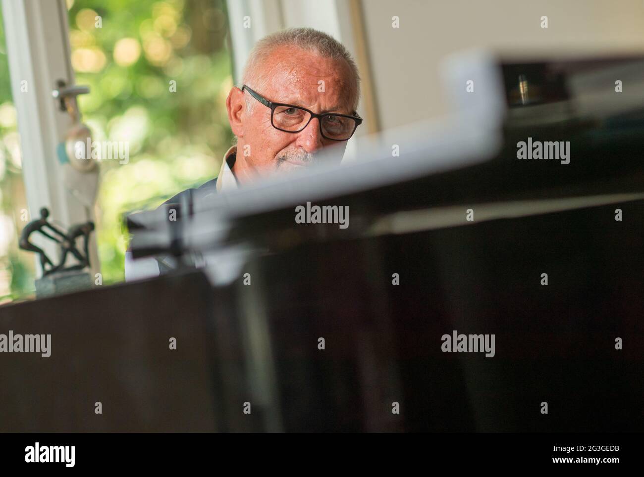 Munich, Germany. 15th June, 2021. The singer Konstantin Wecker photographed during a photo session for the Deutsche Presse-Agentur in his apartment. The musician's new album 'Utopia' will be released on 18.06.2021. Credit: Peter Kneffel/dpa/Alamy Live News Stock Photo