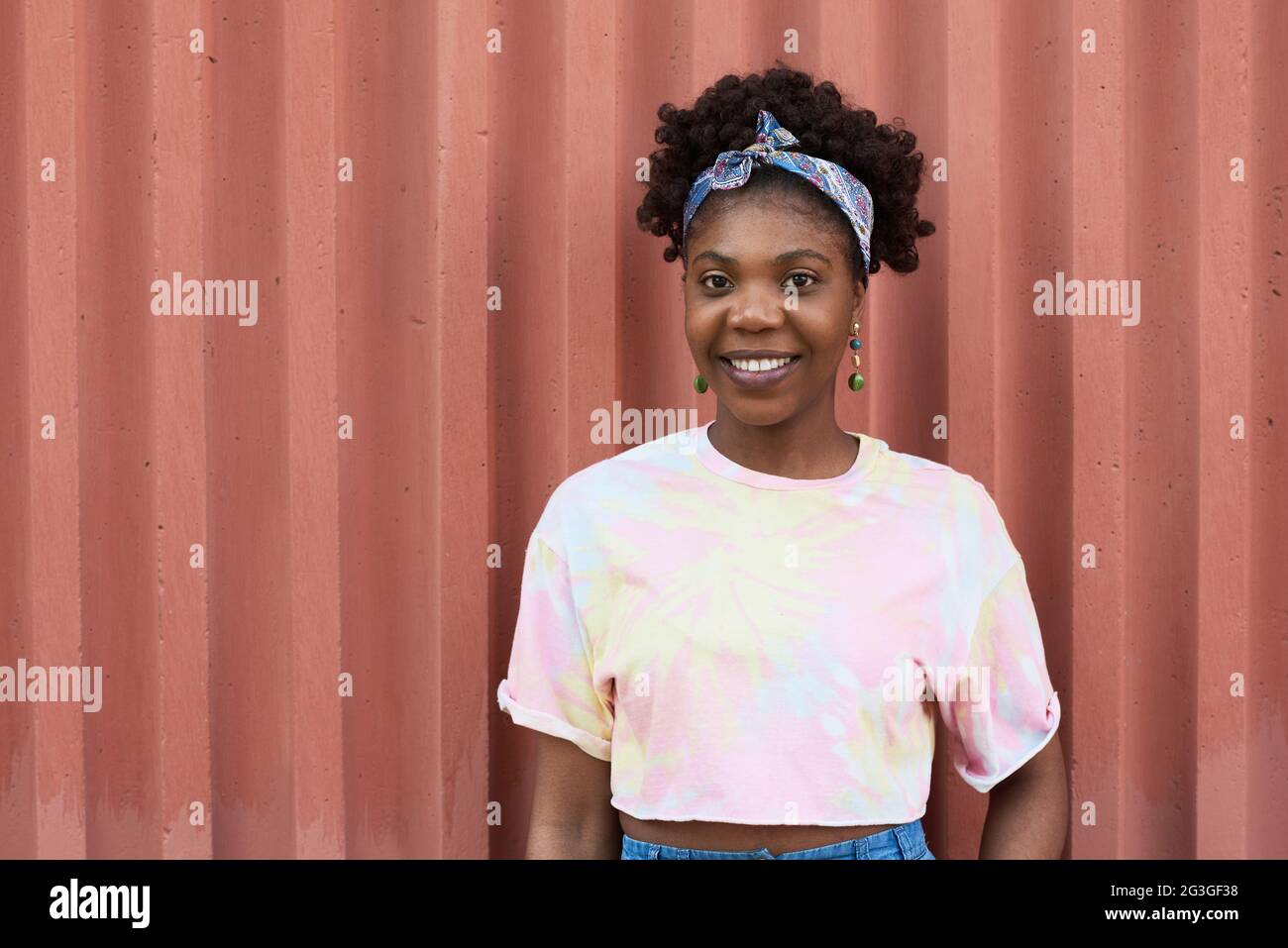 Portrait of African young girl smiling at camera while standing ...