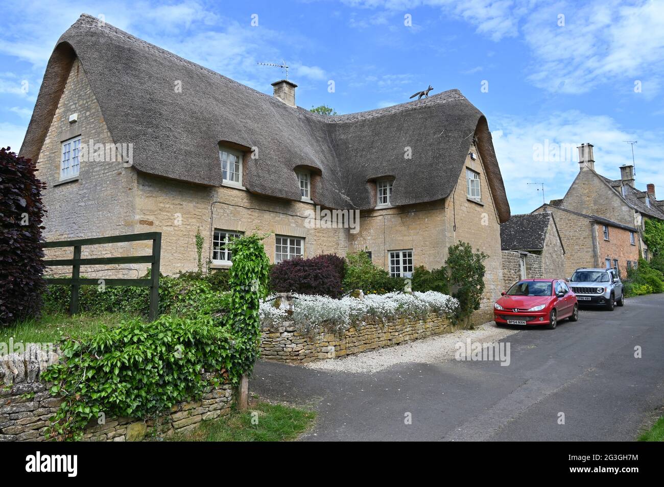 Decorative fox on the thatched roof of Cromwell Cottage in the Gloucestershire village of Bledington Stock Photo
