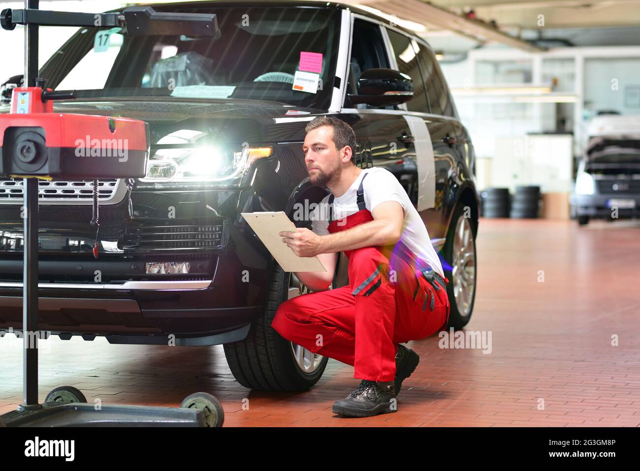 car repair shop worker checks and adjusts the headlights of a car's