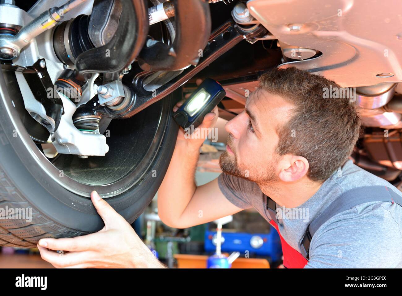 Auto mechanic repairs vehicle in a workshop - checking brakes for safety Stock Photo