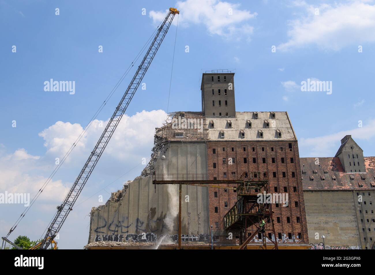16 June 2021, Saxony-Anhalt, Magdeburg: A crane swings a wrecking ball against the roof of the former warehouse in the Port of Science. Half of the building is to be demolished and then converted into a residential building. Photo: Klaus-Dietmar Gabbert/dpa-Zentralbild/ZB Stock Photo