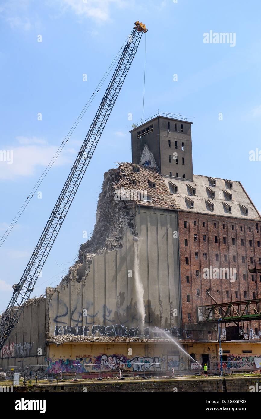 16 June 2021, Saxony-Anhalt, Magdeburg: A crane swings a wrecking ball against the roof of the former warehouse in the Port of Science. Half of the building is to be demolished and then converted into a residential building. Photo: Klaus-Dietmar Gabbert/dpa-Zentralbild/ZB Stock Photo