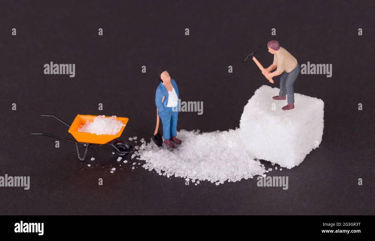 Miniature worker working on a sugar cube Stock Photo - Alamy