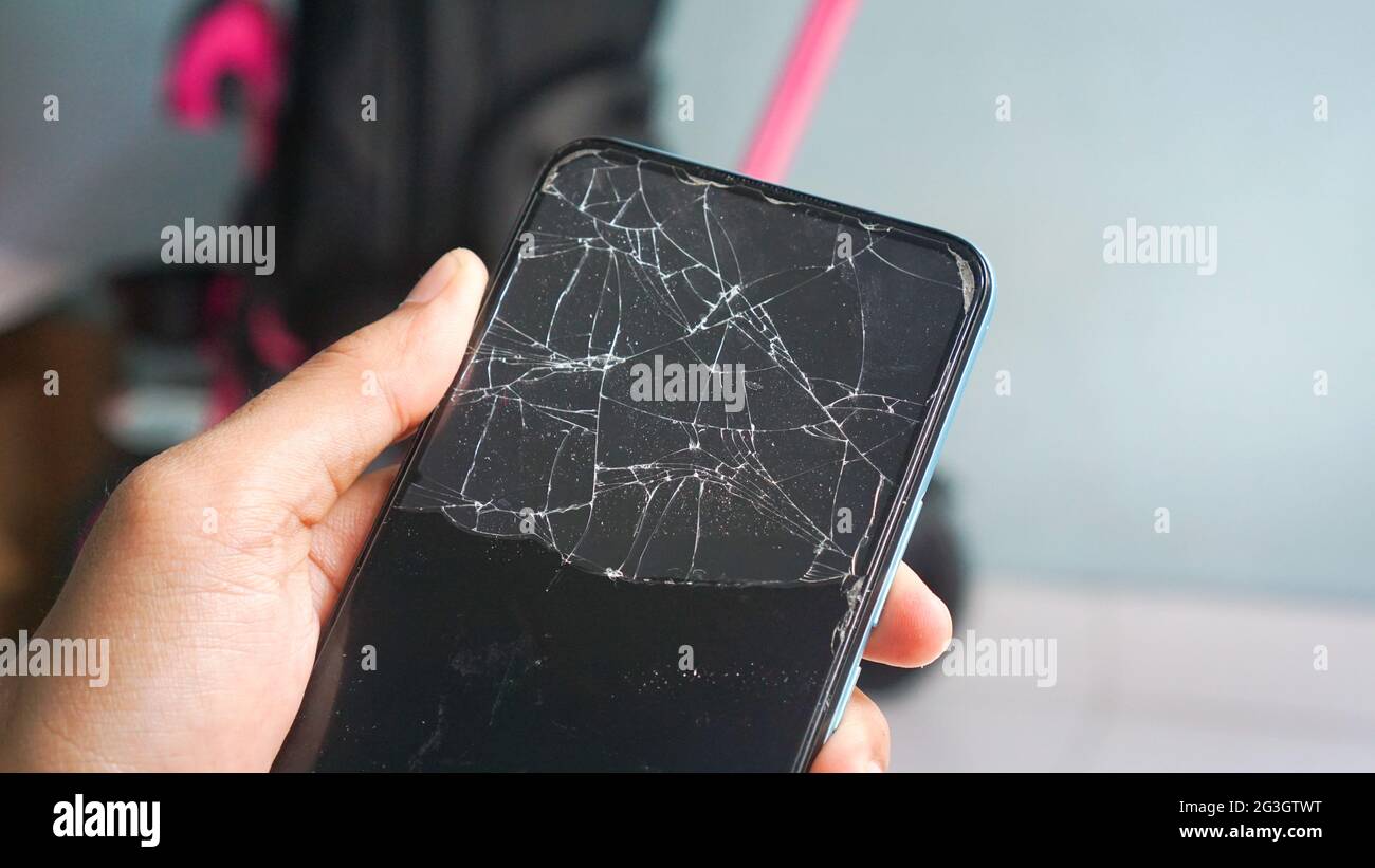 Phone with broken screen cracked, with abstract background close up Stock Photo