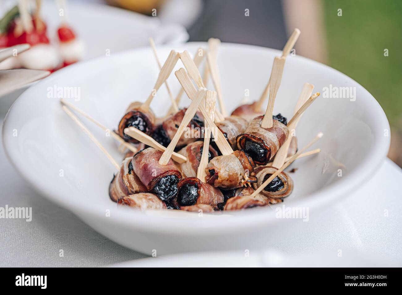 Roasted dried plums wrapped in bacon Stock Photo Alamy