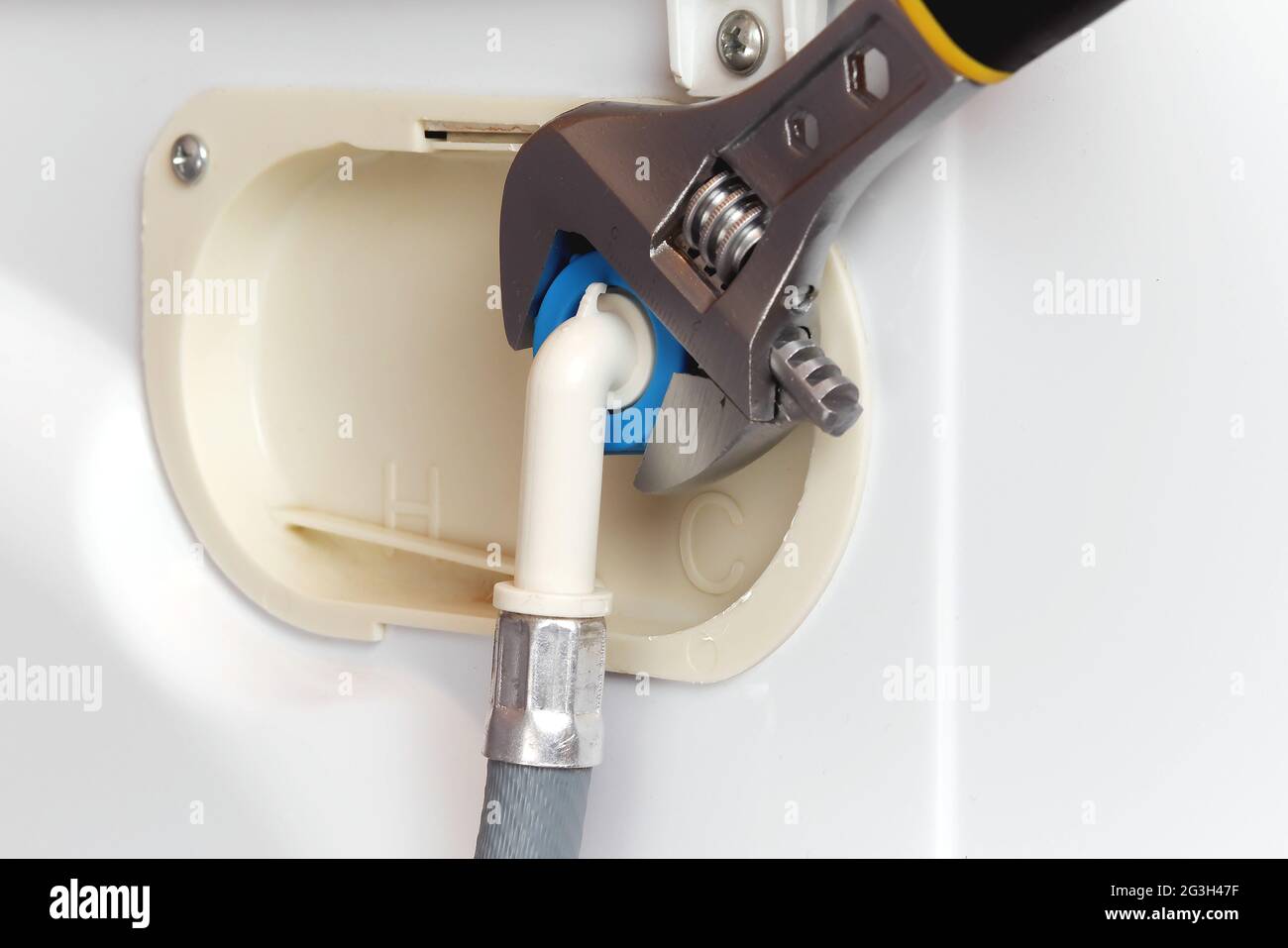 connecting water supply hose to washing machine using adjustable wrench